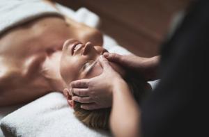 a woman laying on a bed getting a massage at Emerald Valley Apartments in Bovec