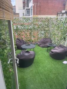 een patio met zitzakken en tafels op het gras bij Spacious 2 Bedroom Apartment in the heart of Soho. in Londen
