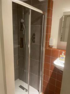 een douche met een glazen deur in de badkamer bij Spacious 2 Bedroom Apartment in the heart of Soho. in Londen