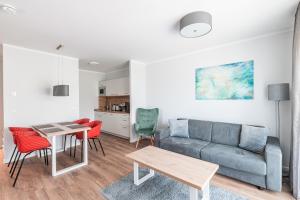 een woonkamer met een bank en een tafel bij Sporthotel Neuruppin - Apartmenthaus mit Ferienwohnungen in Neuruppin