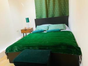 a bedroom with a green bed with a green blanket at London Luxury Apartment with Private Jacuzzi Hot tub & Sauna in London