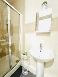 a white bathroom with a sink and a shower at London Luxury Apartment with Private Jacuzzi Hot tub & Sauna in London
