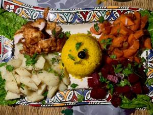 a plate of food with potatoes and vegetables on a table at Your Family Camp in Merzouga