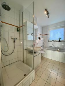 ein Bad mit einer Dusche und einem Waschbecken in der Unterkunft 3 Zimmer Apartment in S-Bahn Nähe, 76 qm, max 5 Pers, 30qm Dachterasse, Garage, Internet 1000 MBit in Gärtringen