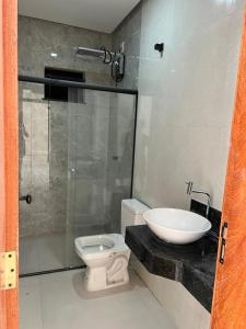 a bathroom with a shower and a toilet and a sink at Ap Praia de Taperapuan Porto Seg in Porto Seguro