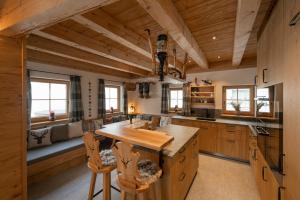 a kitchen with wooden ceilings and a large center island at Engadin Chalet - Private Spa Retreat & Appart -St Moritz - Val Bever in Bever