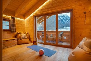 a living room with a large window and a ball on the floor at Engadin Chalet - Private Spa Retreat & Appart -St Moritz - Val Bever in Bever