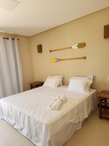 uma cama branca com um bicho de peluche em Villa Garcez em Jaguaripe