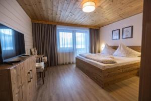 1 dormitorio con 1 cama y TV en Haus Carmen en Stumm