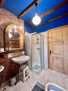 ein Bad mit einer Dusche, einem Waschbecken und einem Spiegel in der Unterkunft Casa Unica- da Bruno in Colico