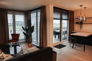 sala de estar con sofá y comedor en Luxe loft appartement in Résidence Marina Kamperland (8 pers.), en Kamperland