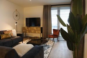 a living room with a couch and a tv at Luxe loft appartement in Résidence Marina Kamperland (8 pers.) in Kamperland