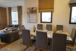 Madinat Jumeirah Living في دبي: غرفة معيشة مع طاولة وكراسي وأريكة