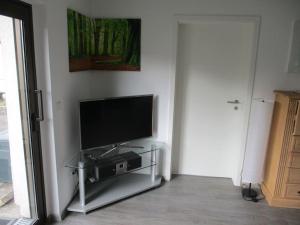 soggiorno con TV a schermo piatto su supporto di Ferienwohnung Mittendrin, Stadtmitte Hermeskeil a Hermeskeil