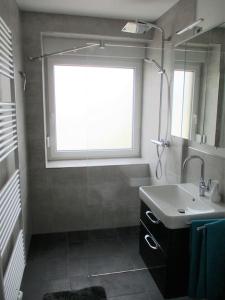 a bathroom with a sink and a window at Ferienwohnung Mittendrin, Stadtmitte Hermeskeil in Hermeskeil