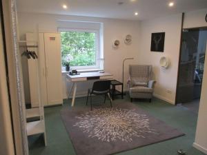 a living room with a table and a chair and a window at Ferienwohnung Mittendrin, Stadtmitte Hermeskeil in Hermeskeil