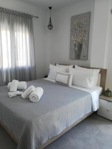 a bedroom with a large bed with towels on it at Aiolos Blu Luxury Apartments in Nea Roda