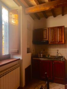 a kitchen with wooden cabinets and a sink and a window at Residenza San Jacopo in Spello