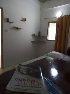 un libro seduto su un tavolo in una stanza di Hostal Paloma Café a Palomino