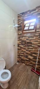 a bathroom with a toilet and a window at CHALÉS MUCIOS in Serra do Cipo