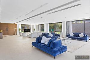 a large living room with blue couches at WelHome - Extraordinary Giant Water Villa on Nurai Island in Abu Dhabi
