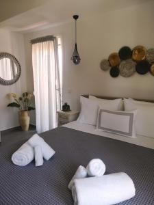 a bedroom with a bed with towels on it at Aiolos Blu Luxury Apartments in Nea Roda