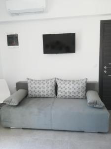 a couch with pillows sitting in a living room at Aiolos Blu Luxury Apartments in Nea Roda