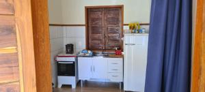 a small kitchen with a sink and a refrigerator at CHALÉS MUCIOS in Serra do Cipo