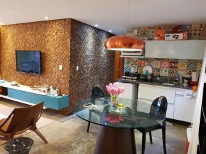 uma cozinha e sala de jantar com uma mesa de vidro em Villas do Pratagy resort Maceió próximo praia em Maceió