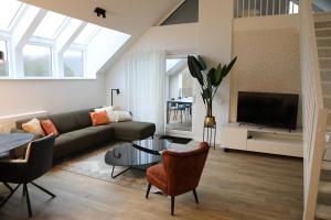 a living room with a couch and a tv at Luxe en comfortabel appartement aan het water in Kamperland