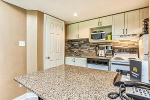 a kitchen with white cabinets and a granite counter top at Condo 904 at North Creek Resort in Blue Mountains