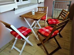 einen Tisch und Stühle mit roten Kissen darauf in der Unterkunft Gemütliche neue Ferienwohnung in La Ciaccia in Codaruina
