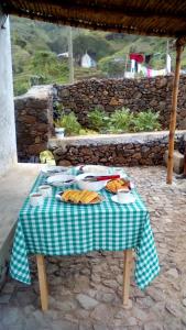 uma mesa de piquenique com pratos de comida em Pousada Dragoeiro Monte Joana Santo Antão em Ribeira Grande