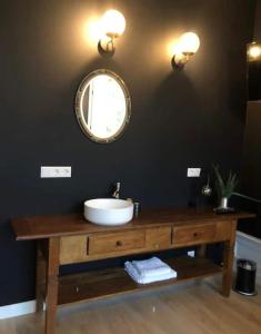 een badkamer met een wastafel en een spiegel bij Statige boerderijwoning met vrij uitzicht en tuin in Hoogzand