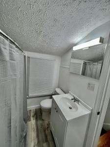 Baño blanco con aseo y lavamanos en 3 BR Home in Kent!, en Kent