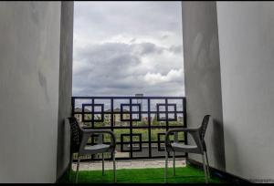 two chairs sitting on a balcony looking out of a window at Eden's Studio apartment in Syokimau