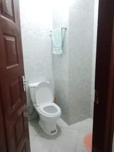 a bathroom with a white toilet in a room at Eden's Studio apartment in Syokimau