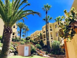 a resort with palm trees and a building at Dona Lola Martha - Spacious 3 bedroom apartment with partial sea views in Mijas