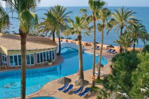 uma vista aérea de um resort com palmeiras e uma piscina em Dona Lola Martha - Spacious 3 bedroom apartment with partial sea views em Mijas