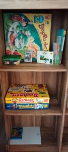 una estantería de libros con una pila de juegos y libros en FeWo in Cranzahl en Cranzahl