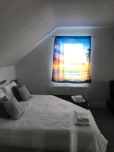 a bedroom with a bed and a window with a blanket at Baywatch, Shannon River View in Droíchead an Chláir