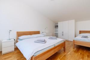 1 dormitorio con 2 camas, armarios blancos y suelo de madera. en Horský apartmán Temari 9 Klínovec, en Loucná pod Klínovcem