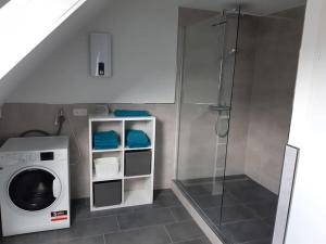 a bathroom with a washing machine and a shower at Ferienwohnung Ganz Oben, Stadtmitte Hermeskeil in Hermeskeil