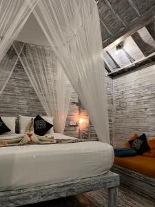 a bedroom with a bed with mosquito netting at The Ocean Sunset Villas Ceningan in Nusa Lembongan