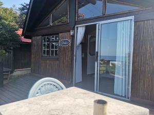 una vista exterior de una casa con una puerta corredera de cristal en Amapondo Backpackers Lodge en Port Saint Johnʼs