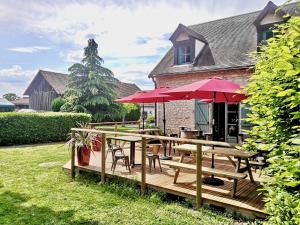 um deque de madeira com mesas e guarda-sóis vermelhos em L'ETAP'CORTELINE em Saint-Rémy