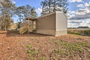 a tiny house on a yard with a porch at Lakefront Wetumpka Escape with Furnished Deck! in Wetumpka