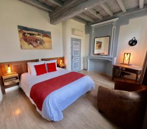1 dormitorio con 1 cama grande con almohadas rojas en L'ETAP'CORTELINE, en Saint-Rémy