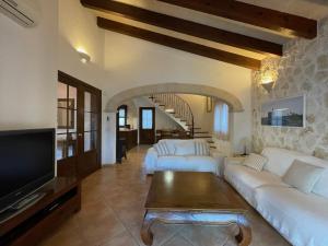 a living room with two white couches and a tv at Villa Noray Cala Morell in Cala Morell