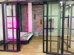Habitación con cama en habitación con puertas de cristal en Soy Local Primavera, en Medellín